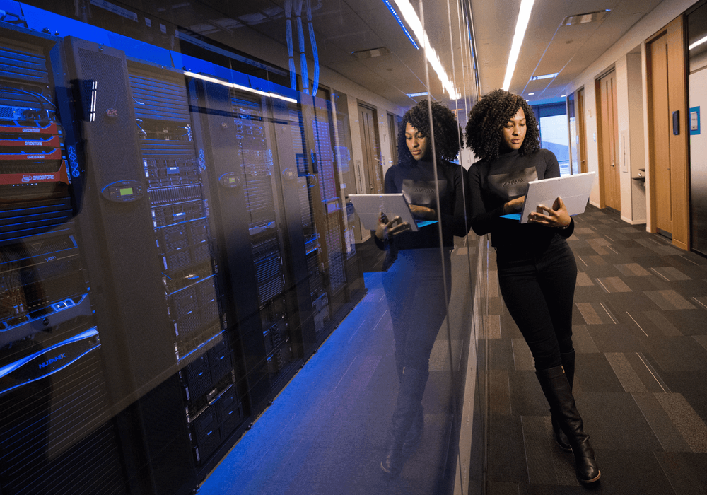 Engineer with a laptop in a data center corridor