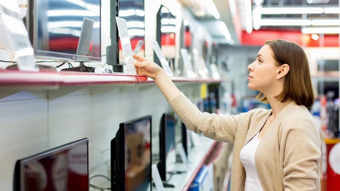 Customer selecting a product from a shelf in a Kotsovolos store